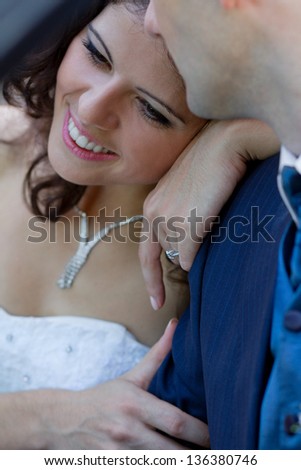 Happy young bride leaning on his strong shoulder
