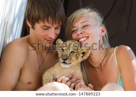 Photo set of people taking care of 2 month old male lion cub