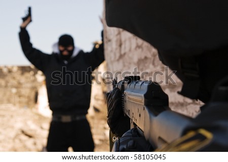 Military policeman taking armed criminal under arrest