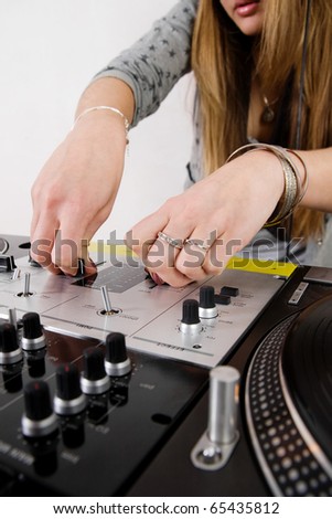 Hands of a disc jockey girl playing music from vinyl