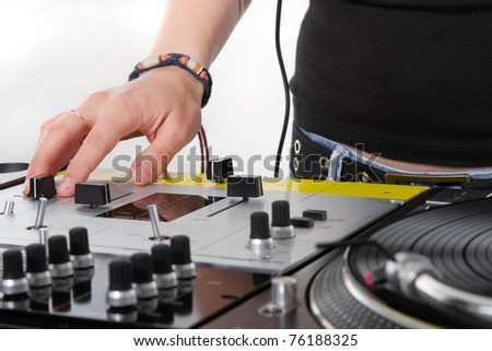 Disc jockey girl adjusting sound level on professional audio mixer