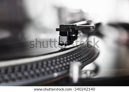 Dj turntable player playing vinyl record disc with hip hop music.Closeup,focus on needle cartridge headshell.Disc jockey audio equipment for scratch.Hifi sound system