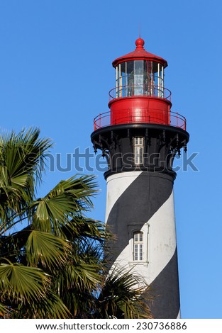 The St. Augustine Lighthouse, with it\'s distinctive black and white spiral topped with a red lantern room, towers above the palms of Florida\'s Atlantic Coast.