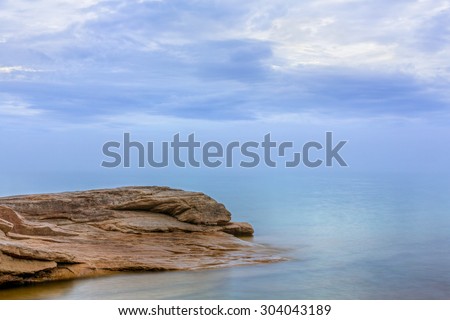 Subtle color and reflections are displayed on a cloudy, misty evening on Lake Superior along rocky Miners Beach at Upper Peninsula Michigan\'s Pictured Rocks National Lakeshore.