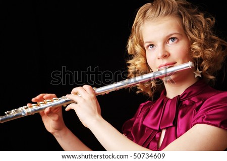 young girl playing the flute on a black background
