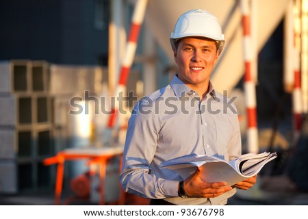 portrait of well-dressed man full of belief in the eyes standing against the construction in hard hat