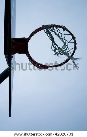 worn basketball hoop just before sunrise