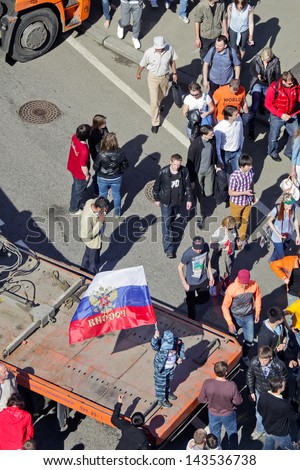 MOSCOW - MAY 09: Small boy in army clothes standing with russian flag among crowd of people on Moscow street during 65th anniversary of Victory Day on May 9, 2013 in Moscow, Russia