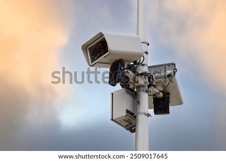 Similar – Image, Stock Photo Surveillance camera on a light pole behind a wall with barbed wire