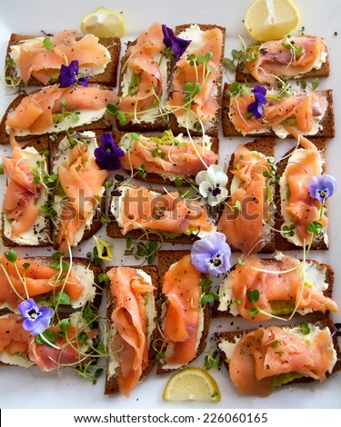 Smoked salmon on ryebread with micro greens and edible flowers for a cocktail party