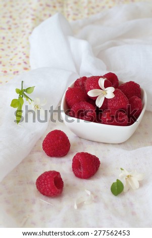 Fresh Raspberries in a bowl with flowers and a floral background