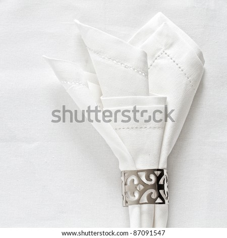 White linen napkin and silver napkin ring on as a table place setting