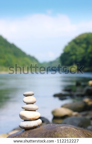Teamwork balance concept. Balance stone on river coast