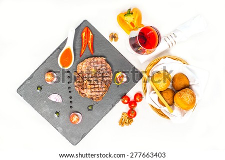 Delicious portion of healthy grilled lean medium rare beef steak cut through and served on a board garnished with fresh herbs and bread