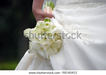 Charming wedding bouquet from kalls in a hand of the bride