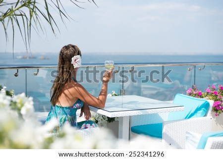 a beautiful girl drinking vine at the beach