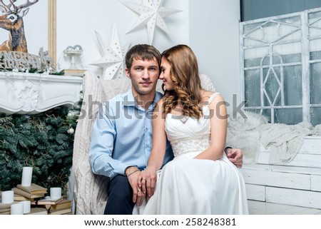Lovely couple sitting by a fireplace on Christmas