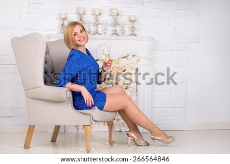 Beautiful luxurious woman on a vintage couch with glass of wine