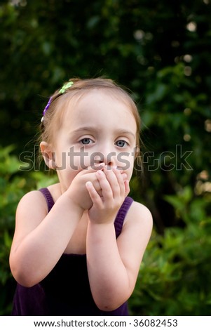 Young girl with hands over mouth.