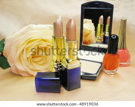two brown lipsticks powder yellow rose eye-shadow and nail polishers