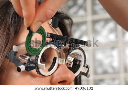 Beautiful young female patient having a medical examination at optician - a series of eye exam related pictures.