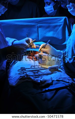 Medical team performing a operation in a dramatically lightened surgery room - a series of SURGERY related images.