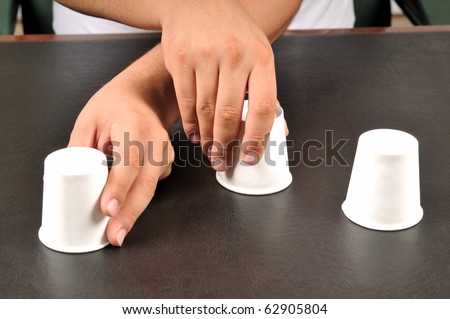 Traditional shell game with three cups - a series of SHELL GAME images.