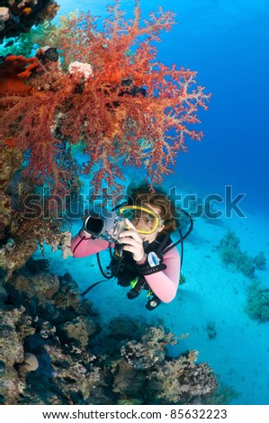 Female diver taking underwater photo.