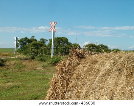 round hay bale at rail crossing