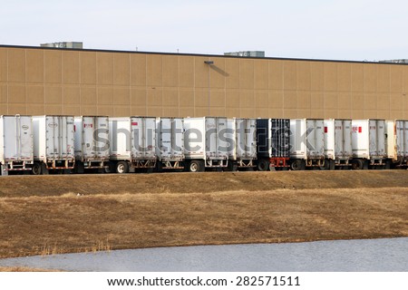 DETROIT, MI-MAY, 2015:  Rear view of trucks waiting to be unloaded at a warehouse or industrial site.