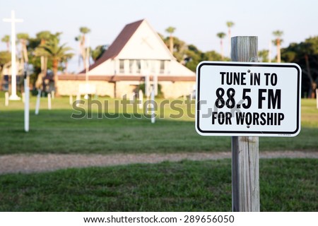 DAYTONA BEACH, FLORIDA-JUNE, 2015:  Sign for a drive-in church in Daytona Beach.  Church goers can sit in their car and listen to the service on the radio.