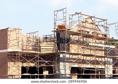 Retail shopping center under construction.  Image shows brick work and scaffolding.