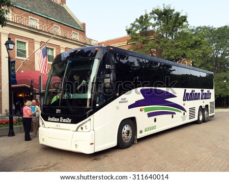 DEARBORN, MI-AUGUST, 2015:  Older tourists board the coach for a tour of the Detroit area.  The hotel in the background is the Dearborn Inn and the people are older.