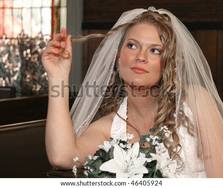 Bride sitting in church twirling her hair