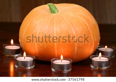 Orange pumpkin and tea light candles. Autumn halloween atmosphere