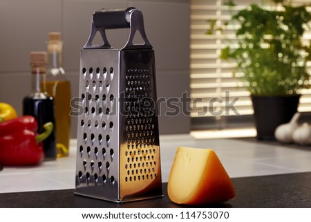 Gouda cheese with a grater in a kitchen