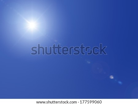 Sun shining bright in a blue sky on a clear day, with lens flare.