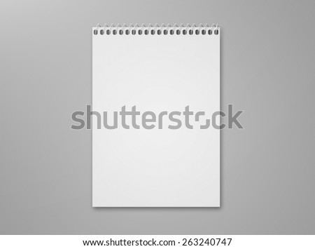 Blank notebook sketch pad with metal spiral with lots of copy space, isolated on a gray background with shadow.