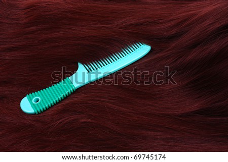 Texture of brunette long hair with green comb
