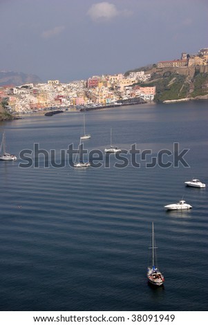 sailboats on the sea, cliffs of Procida clustered with colorful houses in the back