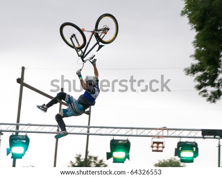 METTMENSTETTEN - JULY 17: BMX jump athlete Raeber Christian shows his moves at water jump competition freestyle-night July 26, 2010 in Mettmenstetten, Switzerland. A  water pool offers secure landing.