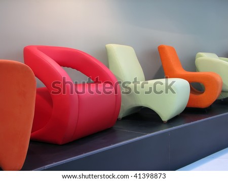 colorful arm chairs on the exhibition. home furniture in various colors.