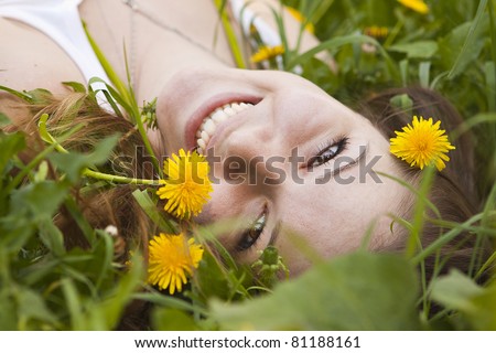Happy girl sitting outdoor lying in dandelion meadow