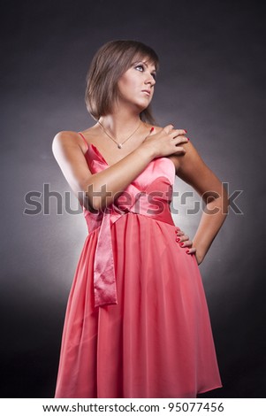 closeup portrait of brunette girl in pink dress in studio