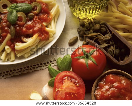 A Still life of Tomato souce and Pasta, oil, bread, garlic and basil