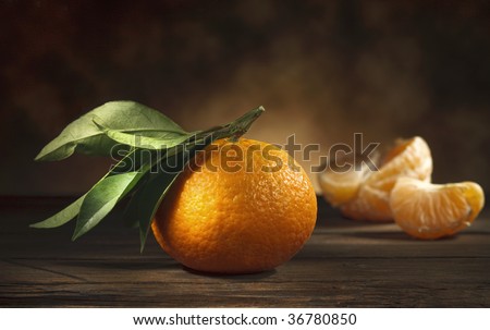 A classic still life of a mandarin on a wooden table