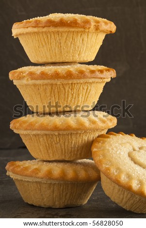 Five apple pies on a slate background