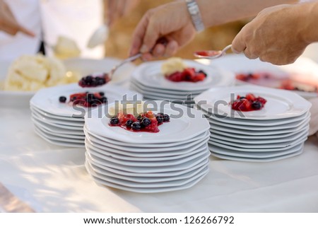 Waiter serving some plates with dessert