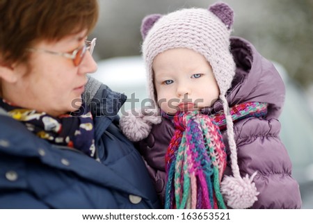 Grandmother and a little girl at winter day