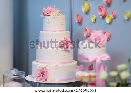 White wedding cake decorated with sugar pink flowers